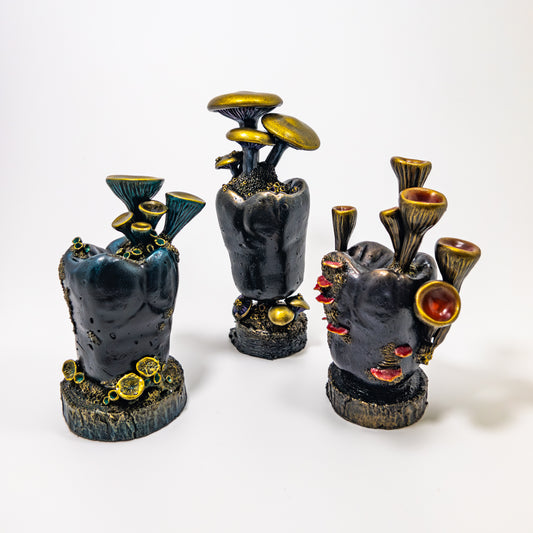 Set of three fungi-covered dental model teeth sculptures, each inside its own glass cloche dome.